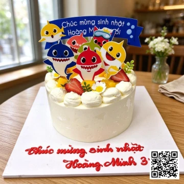 Bánh sinh nhật tròn phủ kem tươi trắng chủ đề Baby Shark, trang trí nhân vật cá mập, trái cây và hoa kem.