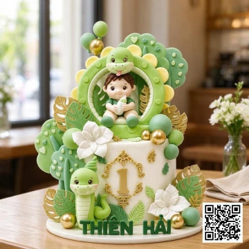 Bánh sinh nhật bé trai 1 tuổi 2 tầng chủ đề năm rắn, màu xanh lá cây và trắng, có mô hình em bé và rắn.