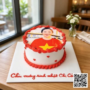 Bánh sinh nhật hình tròn nền kem trắng, viền đỏ, in ảnh chân dung và trang trí trái tim nhỏ.